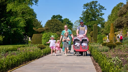 A family of five walking down the newly improved path in the Long Garden at Cliveden, Buckinghamshire.